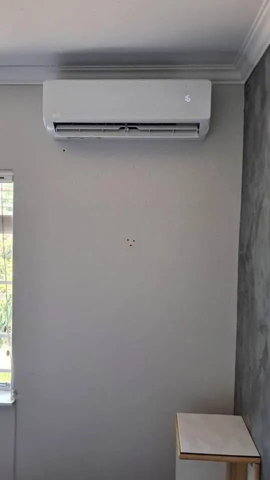 Aircon indoor unit on a grey wall below the cornice
