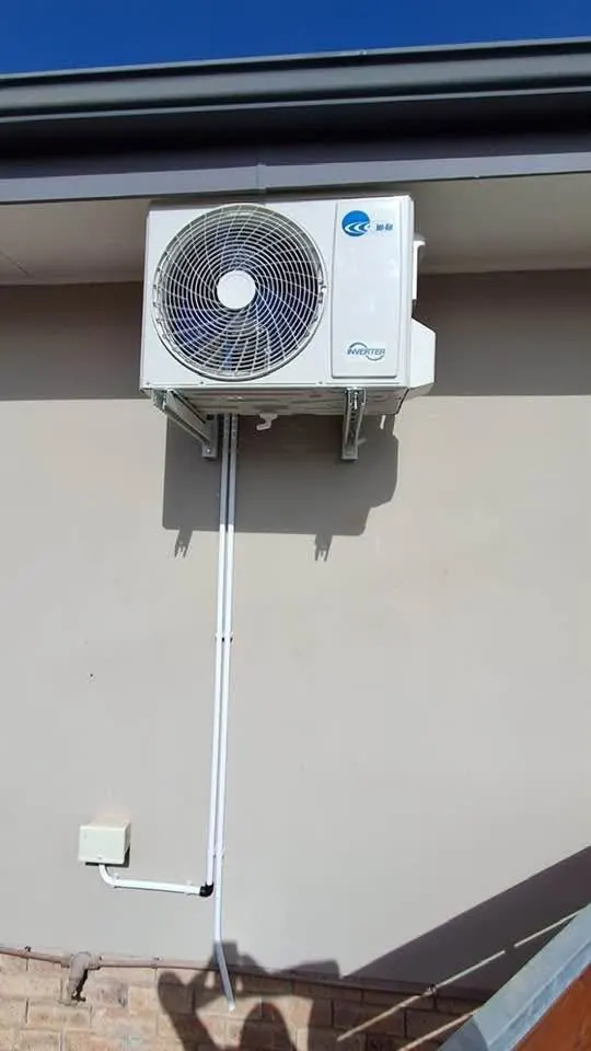 Inverter aircon outdoor unit under the eaves on brackets with pipe cover